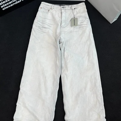 One pair of light wash wide leg jeans shown full length with the tag still attached