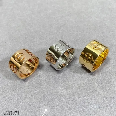 Three wide band rings in gold, silver and gold, lined up on a white surface